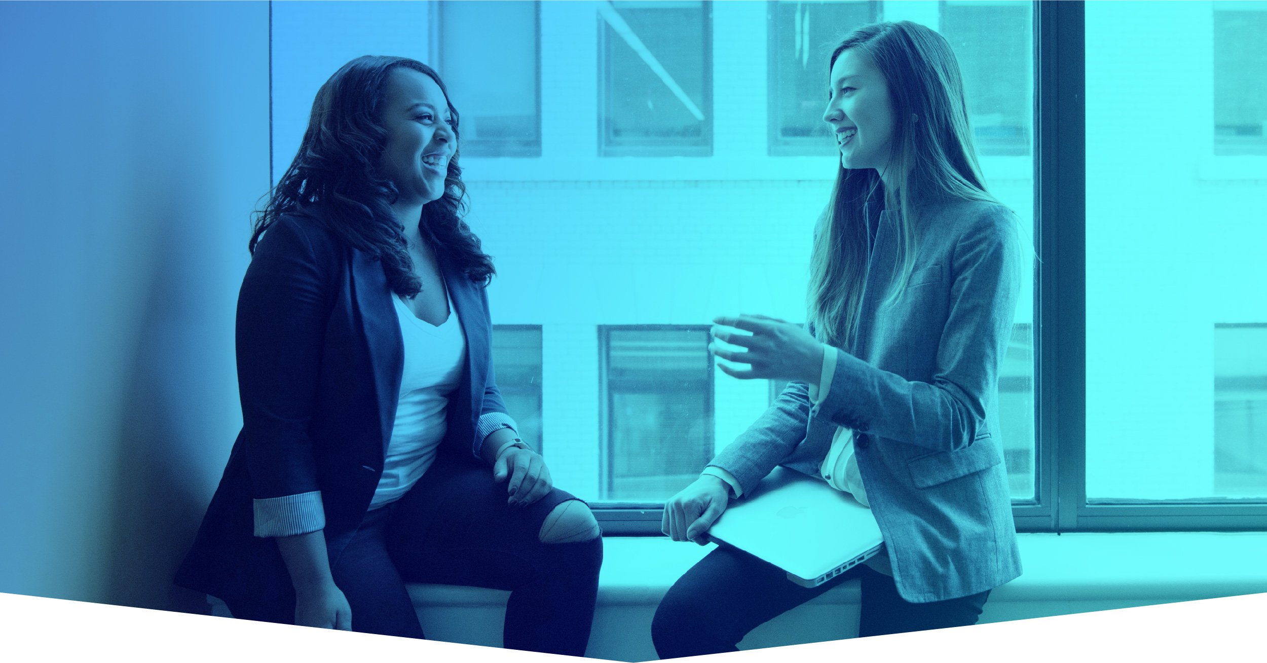 Two office women happily talking